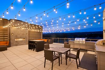 a patio with a table and chairs under lights at Avenue C Apartments, Montana