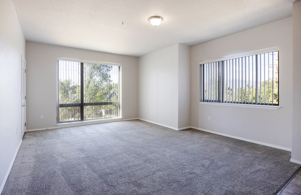 A spacious room with a large carpeted floor and two windows. at Ashlyn Place, Missoula, Montana