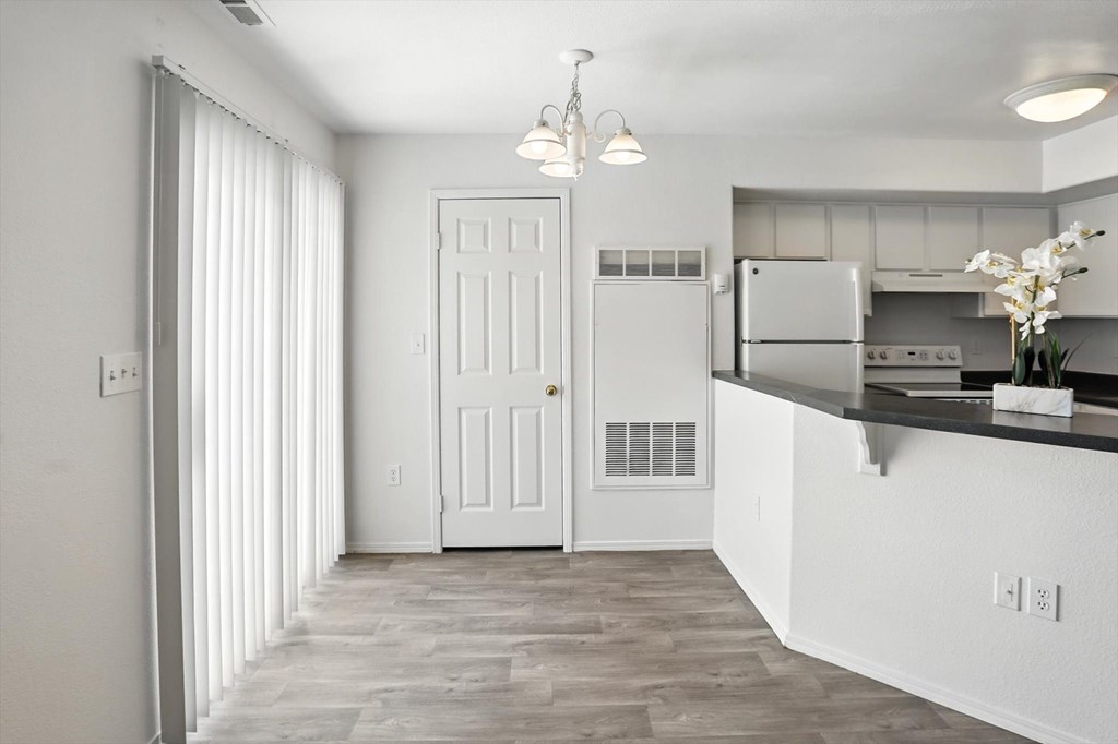 A kitchen with white cabinets and a white door. at Oakstone Apartments, Clearfield, 84015