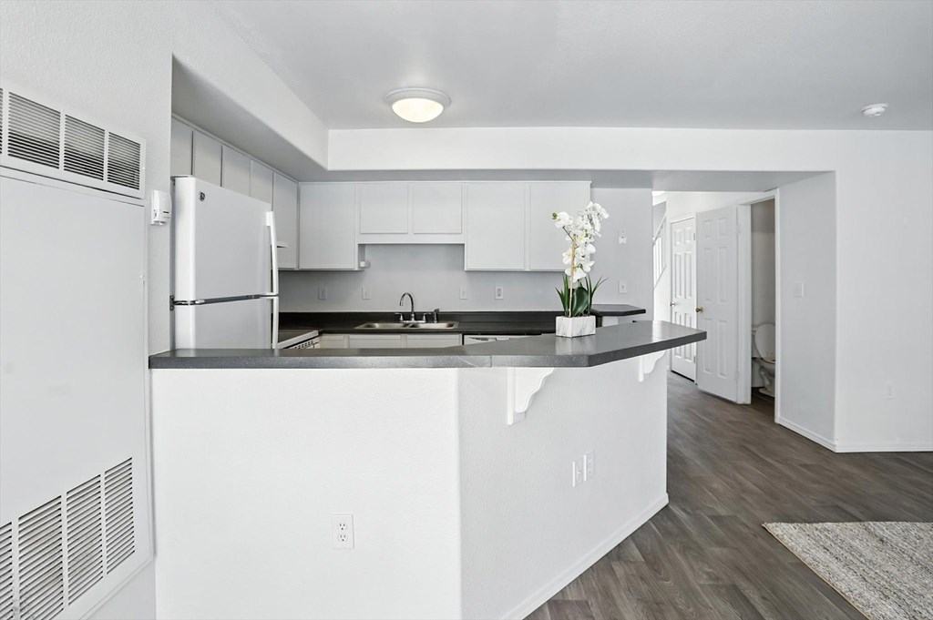 A modern kitchen with white cabinets and a black countertop. at Oakstone Apartments, Clearfield, Utah