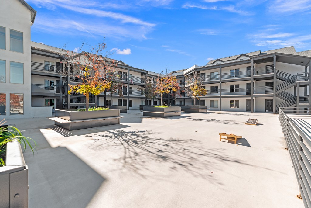 a courtyard with benches and buildings at the apartments