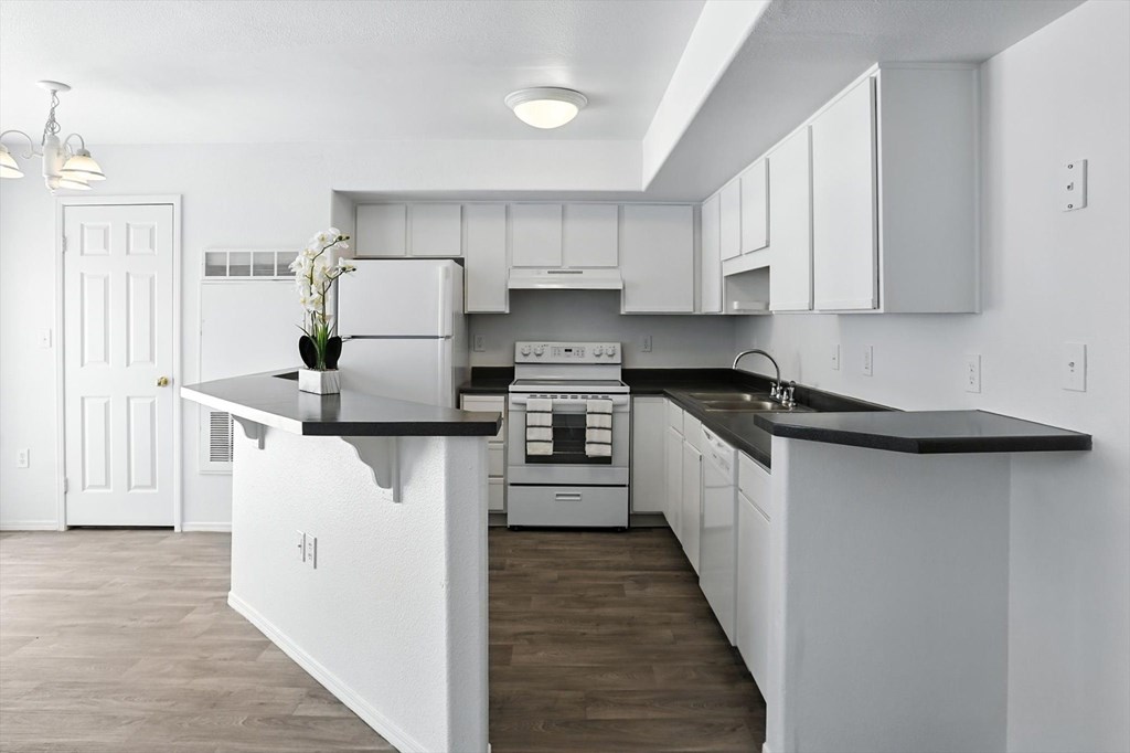 A kitchen with white cabinets and a black countertop. at Oakstone Apartments, Clearfield, 84015