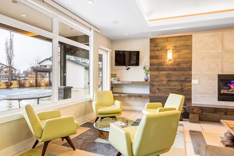 a living room with yellow chairs and a fireplace at Corso Apartments, Missoula, MT