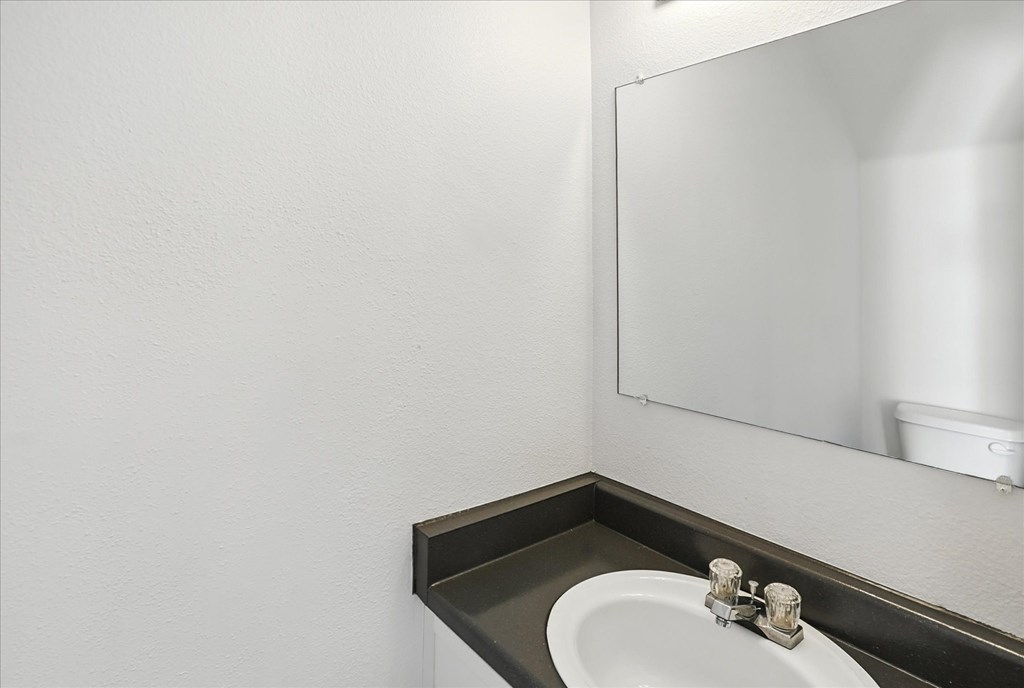 A bathroom sink with a mirror above it. at Oakstone Apartments, Clearfield, 84015