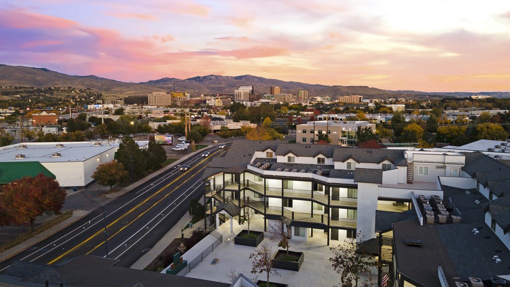 an aerial view of a building with a city in the background