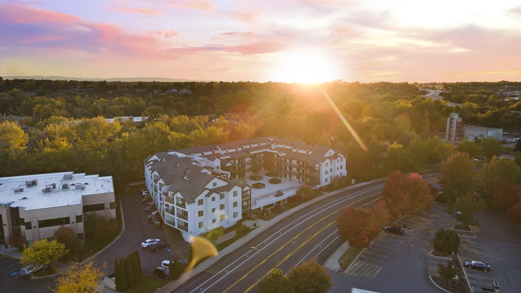 an aerial view of a building with the sun setting behind it