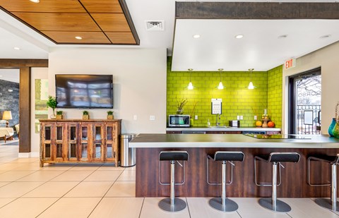a kitchen with green tiles and a bar with stools at Corso Apartments, Missoula, MT