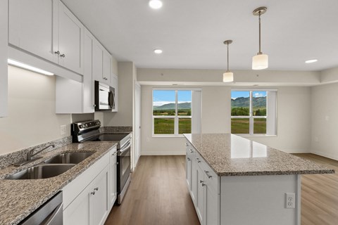 A kitchen with granite countertops and white cabinets at The Beaumont Apartments, Bozeman, Montana 59715