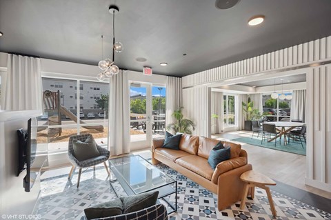 A modern living room with a brown leather sofa and a glass coffee table.