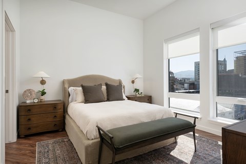 A bedroom with a large bed and a view of the city.