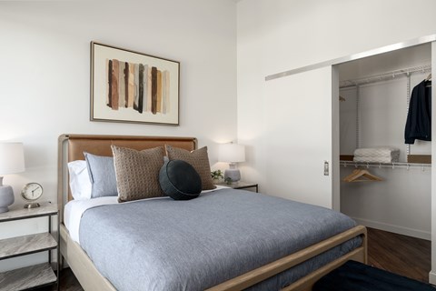 A bedroom with a large bed and a painting on the wall.