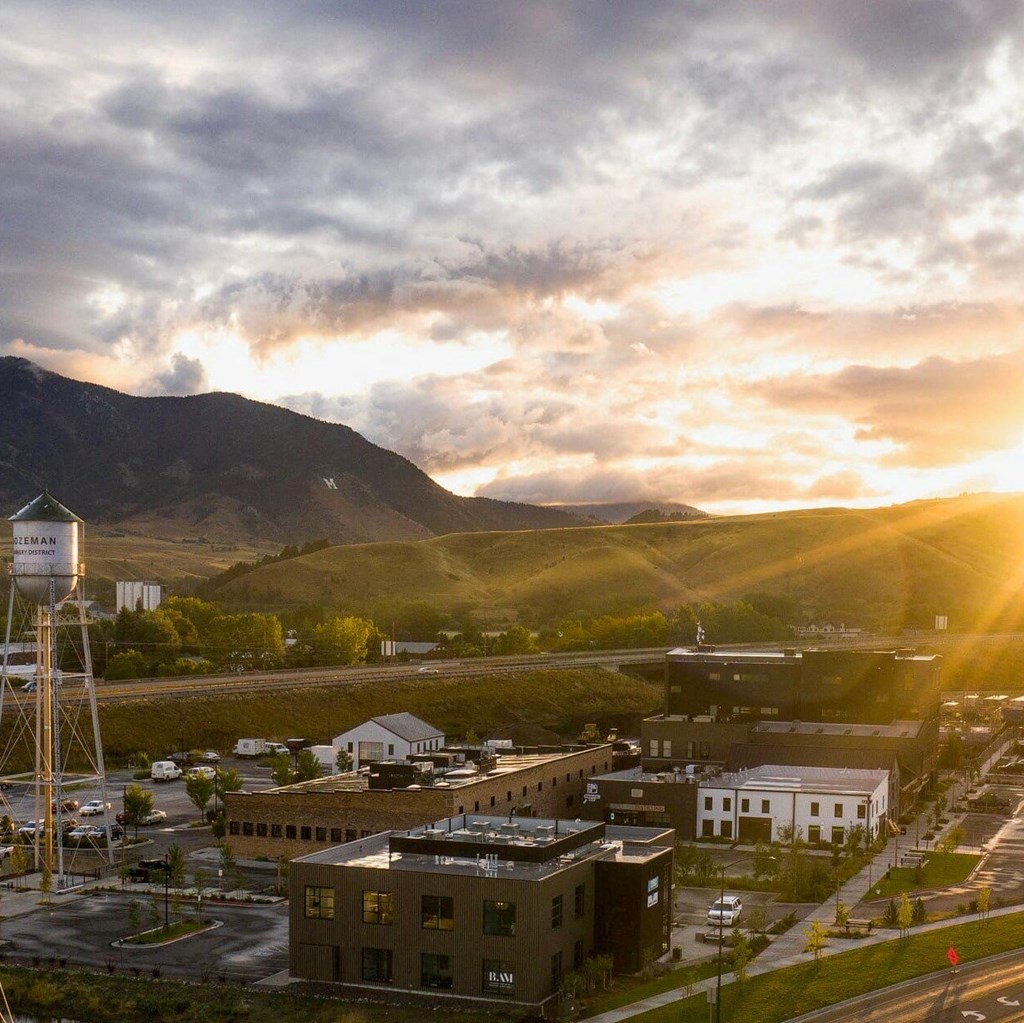 a city at sunset with the mountains in the background