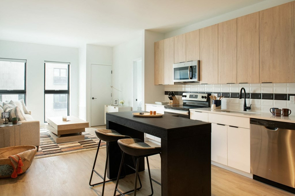 a kitchen with wooden cabinets and a black island with two stools