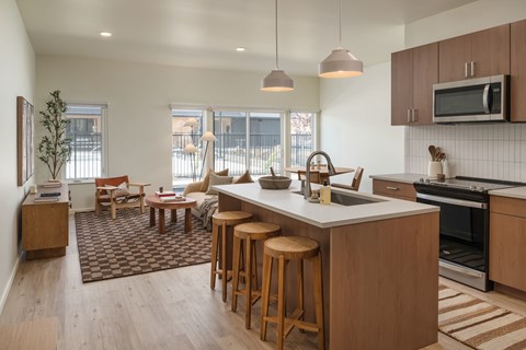 A kitchen with wooden cabinets and a large island with stools.