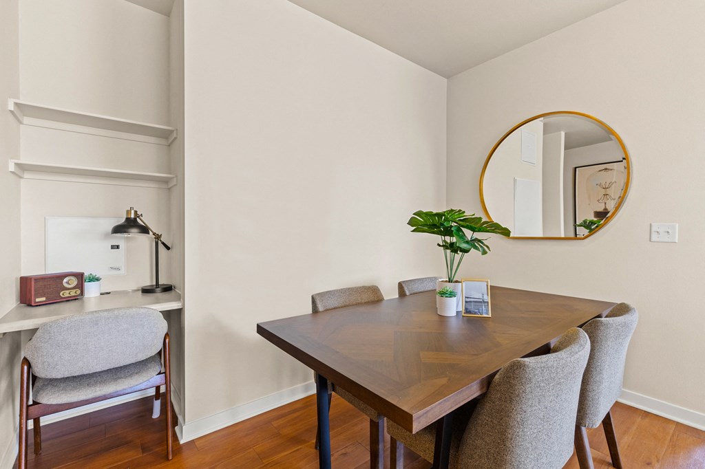 Chic seperate dining room with a patterned wood table next to a small built-in desk with wall shelving and a grey chair at Sylvan Uptown, Denver, CO