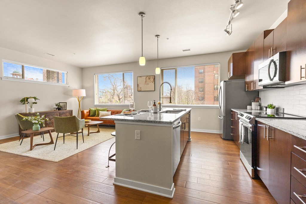 Spacious kitchen with hardwood flooring and an island with view into well-decorated living room at Sylvan Uptown, Colorado, 80203