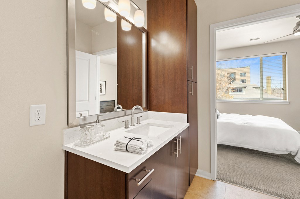 Modern sytle bathroom vanity with marble-look countertops with a view into the bedroom at Sylvan Uptown, Colorado, 80203