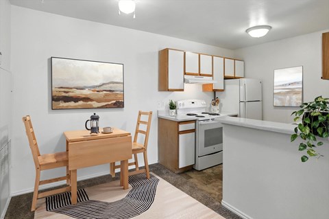 A kitchen with a table and chairs and a painting on the wall.