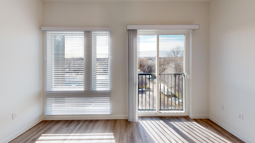 an empty living room with sliding glass doors to a balcony