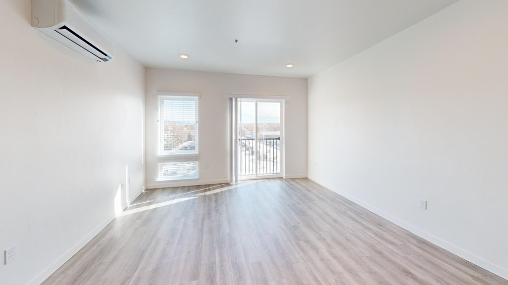 an empty living room with white walls and wood floors