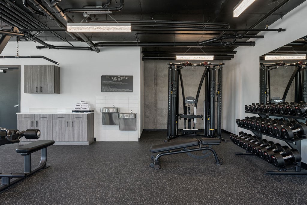 a gym with weights and other equipment in the corner of a room at Crosshatch, Garden City