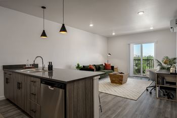 an open kitchen and living room in a home with white walls and wood floors
