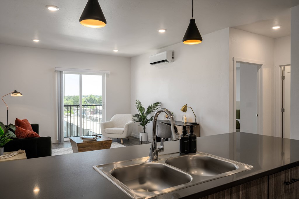 a kitchen counter with a sink and a view of a living room
