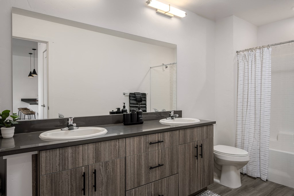 a bathroom with two sinks and a toilet and a mirror at Crosshatch, Idaho