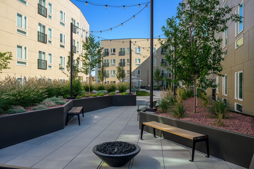 a courtyard with benches and plants and buildings in the background at Crosshatch, Garden City
