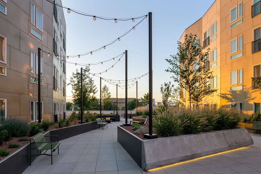 a courtyard with benches and chairs in front of an apartment building at Crosshatch, Garden City, Idaho