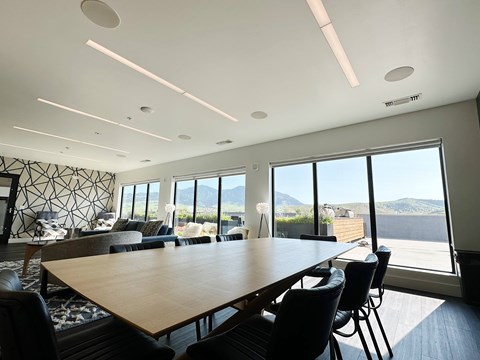 A conference room with a long table and chairs, a patterned wall, and a view of the mountains outside the windows at Cannery Flats, Bozeman, Montana