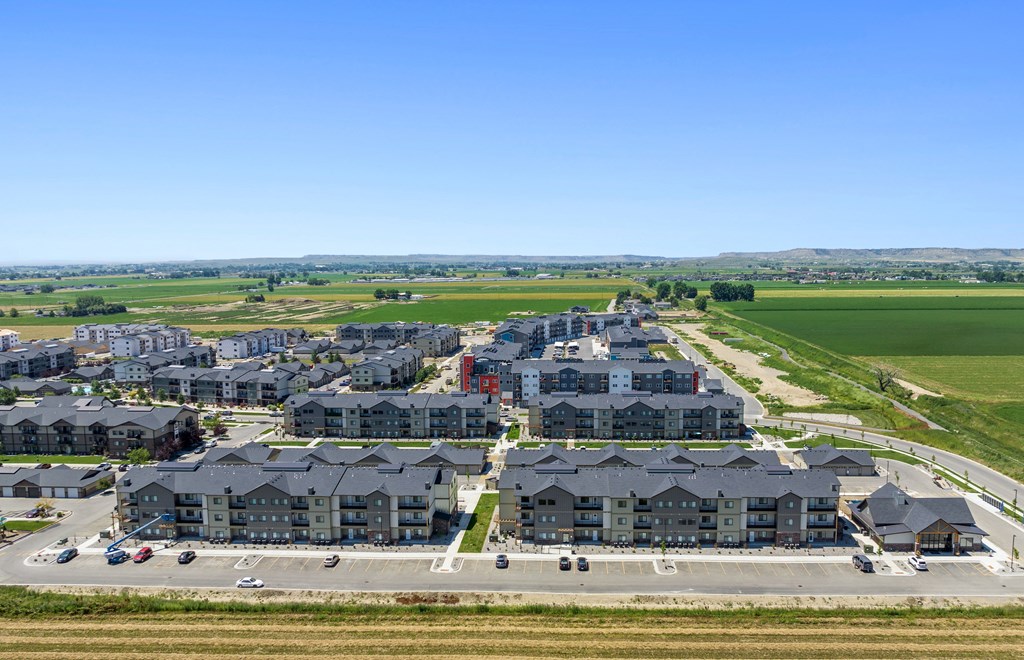 a suburb of a city with houses on a road and a field