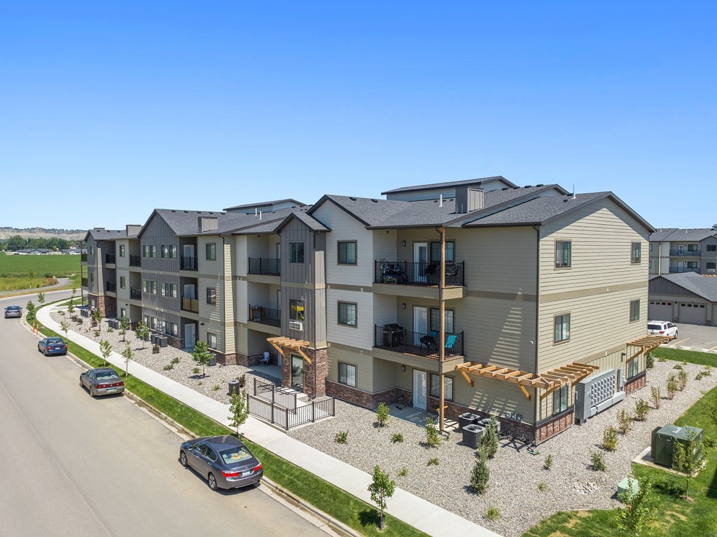 an aerial view of an apartment building with cars parked on a street