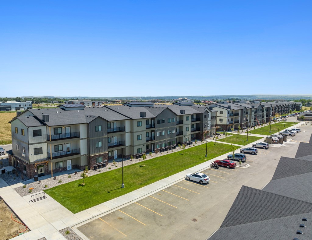 an aerial view of an apartment complex with cars parked in a parking lot