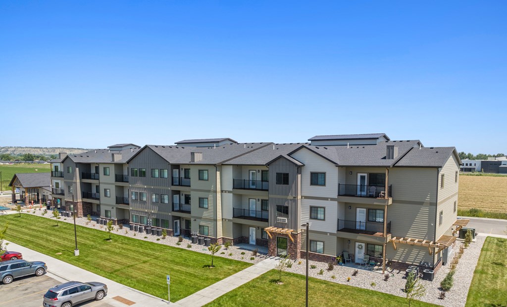 an aerial view of an apartment building with cars parked in a parking lot