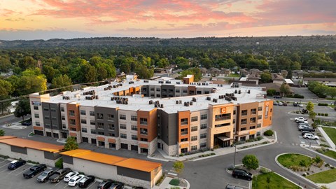 an aerial view of an apartment complex with a sunset in the background at Avenue C Apartments, Montana, 59102