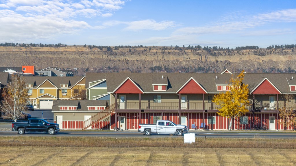 A large building with a red roof is surrounded by a field.
