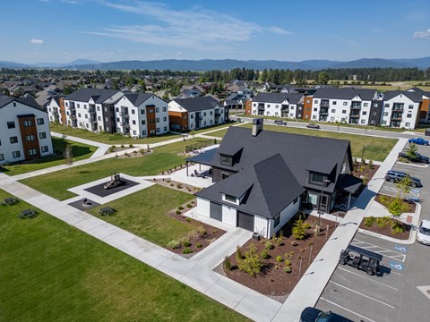 A large building with a black roof is surrounded by a parking lot and other buildings. at Silverbrook Apartments, Kalispell 59901