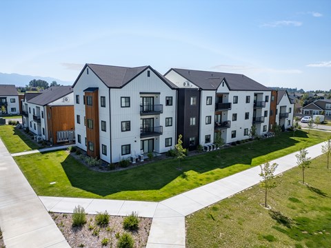 A row of modern townhouses with a sidewalk and landscaping in front. at Silverbrook Apartments, Kalispell 59901