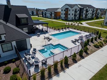 A swimming pool surrounded by a black fence and a grassy area. at Silverbrook Apartments, Kalispell