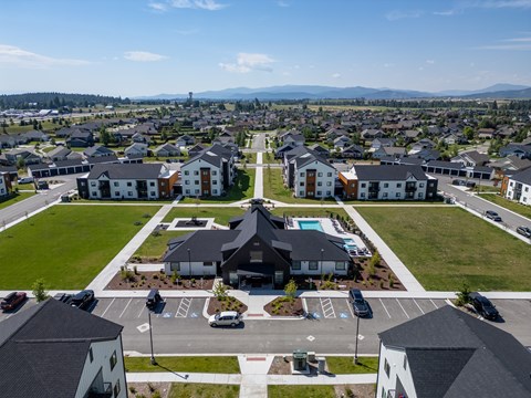 A large building with a pool in the middle of a parking lot. at Silverbrook Apartments, Montana
