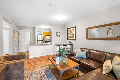 A living room with a brown couch and a wooden coffee table.