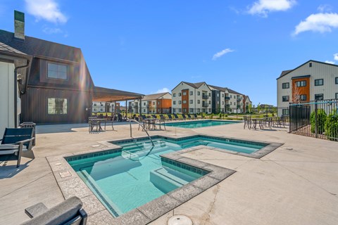 Soothing spa with view of the pool surrounded by pool chairs and tables at Silverbrook Apartments, Kalispell, 59901