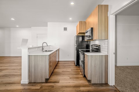 A modern kitchen with wooden cabinets and stainless steel appliances at Silverbrook Apartments, Kalispell, MT