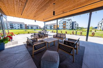 A patio with a table and chairs under a wooden roof. at Silverbrook Apartments, Kalispell, MT, 59901