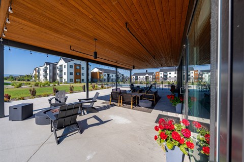 A patio with a wooden roof and a table with chairs. at Silverbrook Apartments, Kalispell, MT