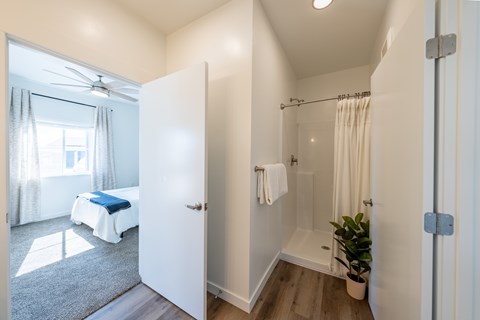 A white bathroom with a bed in the background. at Silverbrook Apartments, Montana, 59901