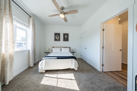 A bedroom with a bed, a ceiling fan, and two pictures on the wall. at Silverbrook Apartments, Kalispell, MT, 59901