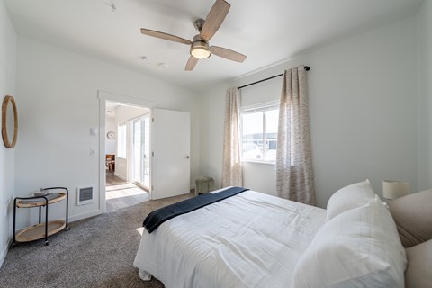 A bedroom with a large bed and a ceiling fan. at Silverbrook Apartments, Kalispell, MT
