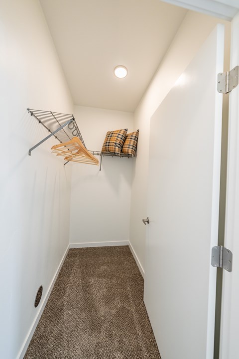 A hallway with a brown carpet and a white wall. at Silverbrook Apartments, Kalispell 59901